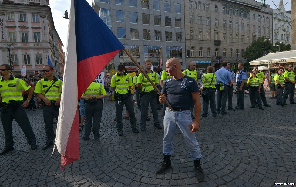 Ультраправый активист держит чешский национальный флаг во время антииммигрантского митинга 18 июня 2015 года в Праге в знак протеста против предложенной Европейской комиссией квоты для обязательных мигрантов.