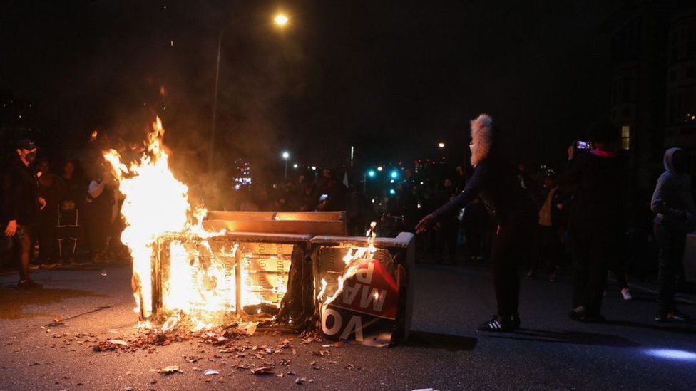 Demonstrators stand near a burning barricade in Philadelphia