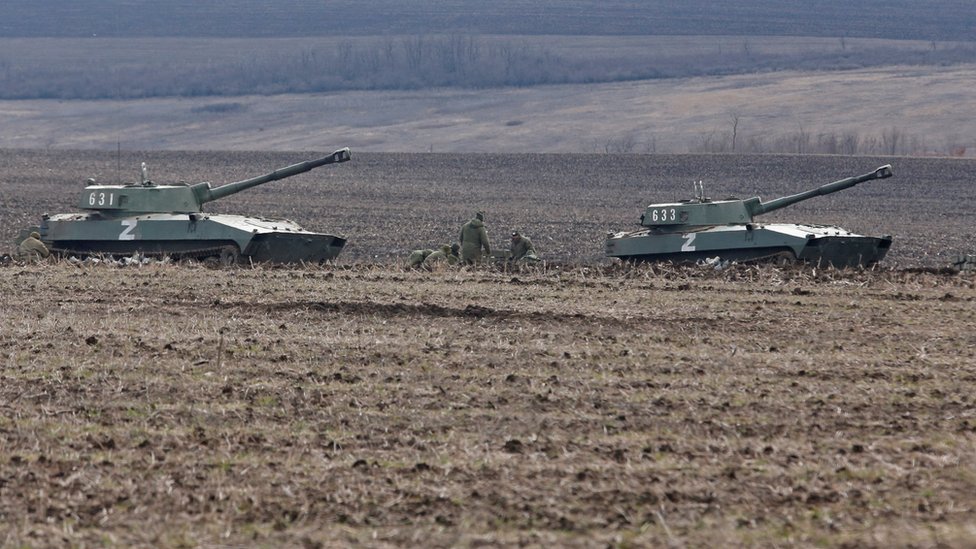 Los miembros del servicio de las tropas prorrusas en uniformes sin insignias se ven junto a vehículos blindados en la región de Donetsk.