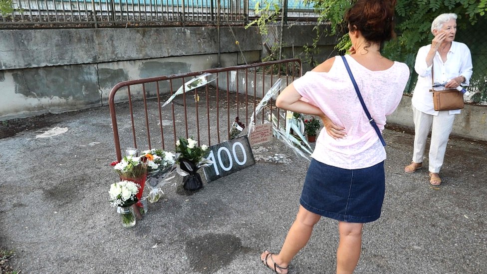 Женщины смотрят на цветы, стоя на месте, где накануне была найдена мертвой женщина в Кань-сюр-Мер 2 сентября 2019 года, что сделало ее сотой жертвой фемицида во Франции в этом году
