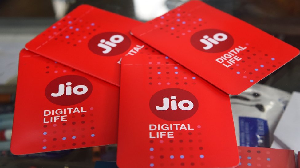 Владелец магазина демонстрирует сим-карты JIO в магазине мобильных телефонов в Мумбаи 19 июля 2017 года.