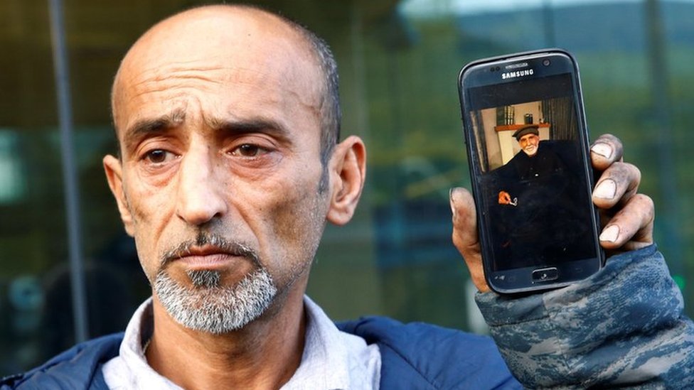 Omar Nabi sostiene un teléfono con una foto de su padre Daoud, que murió en el ataque.