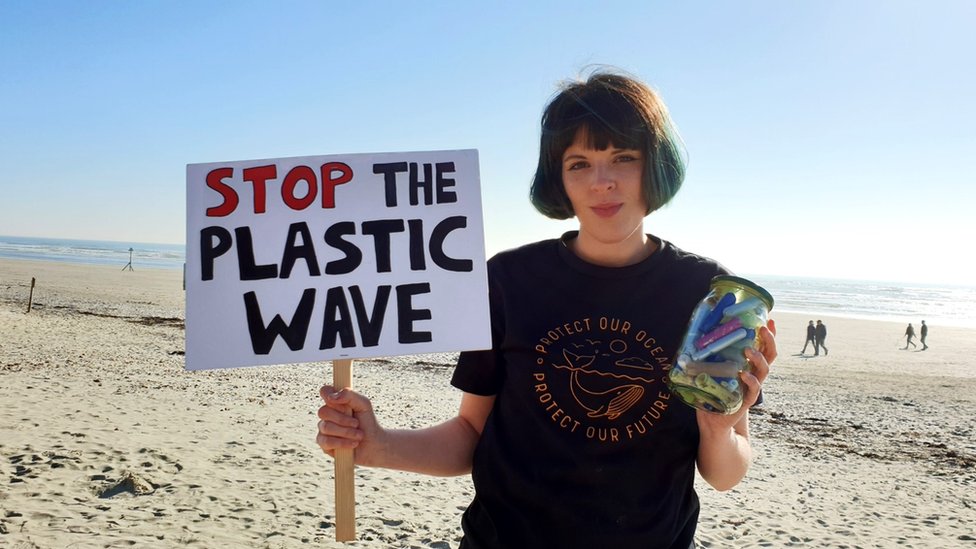 Элла Дайш держит плакат с надписью «Останови пластиковую волну»