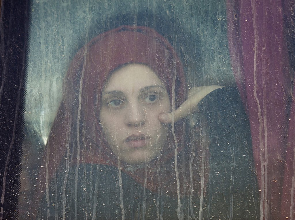 Молодая женщина смотрит в окно автобуса