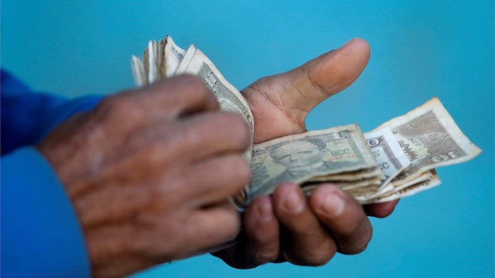 Cubano maneja billetes.