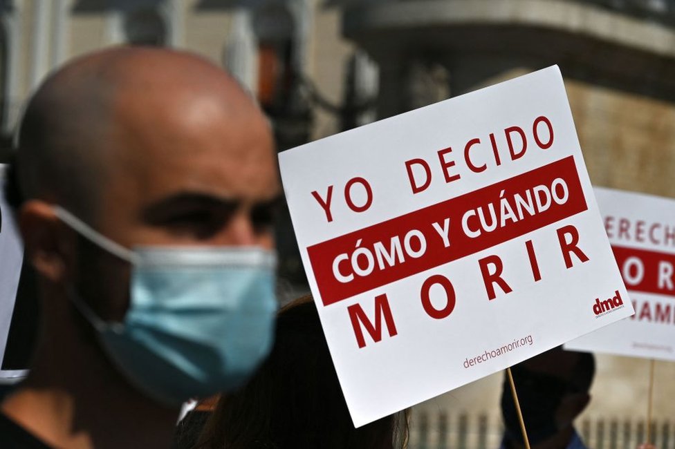 Un hombre sostiene un cartel que dice &quot;Yo decido cómo y cuándo morir&quot; durante una protesta a favor del suicidio asistido en la Puerta de Sol, en Madrid, España, el 25 de junio de 2021.
