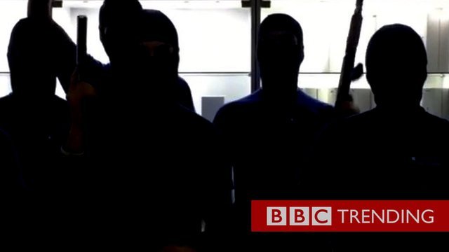 Silhouetted image of smartphone sellers dressed as militants