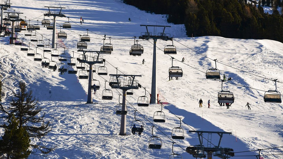 Tourists take chairlifts and enjoy skiing in the Stelvio National Park resort in Bormio, Italian Alps