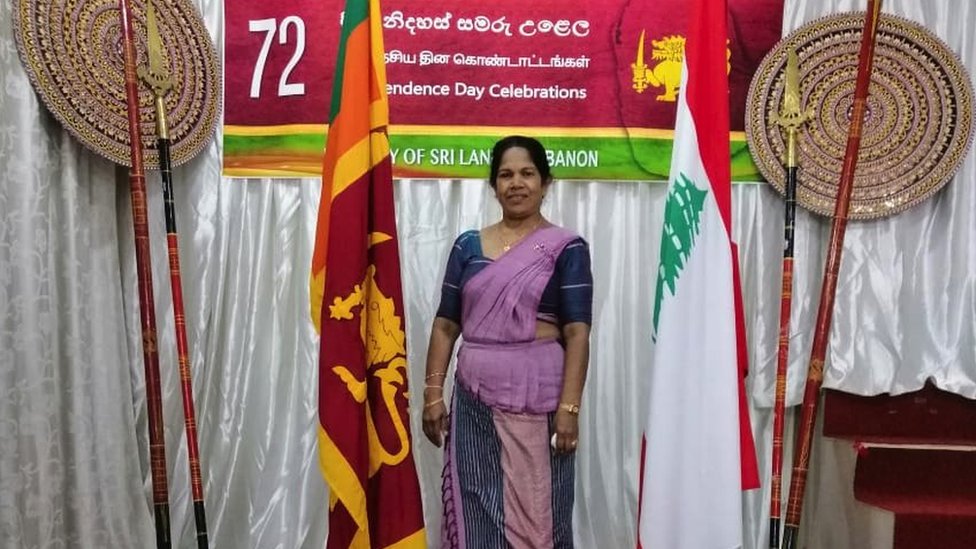 Chandra berpose di samping bendera Sri Lanka dan Lebanon