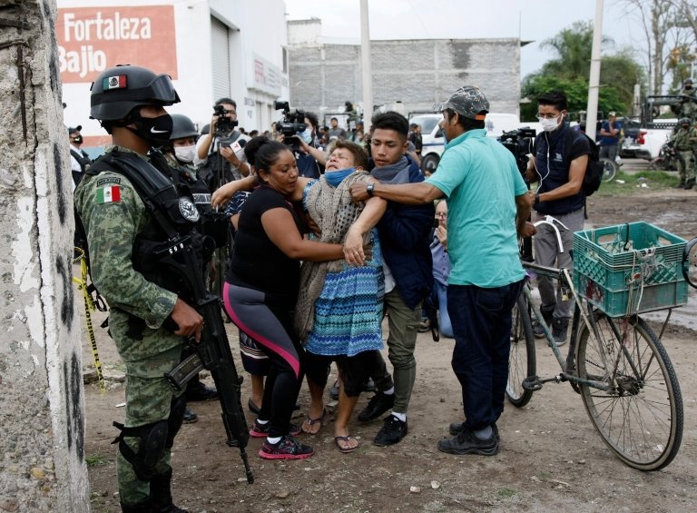 Женщина реагирует около места преступления, где были убиты 24 человека, в Ирапуато, штат Гуанахуато, Мексика, 1 июля 2020 г.
