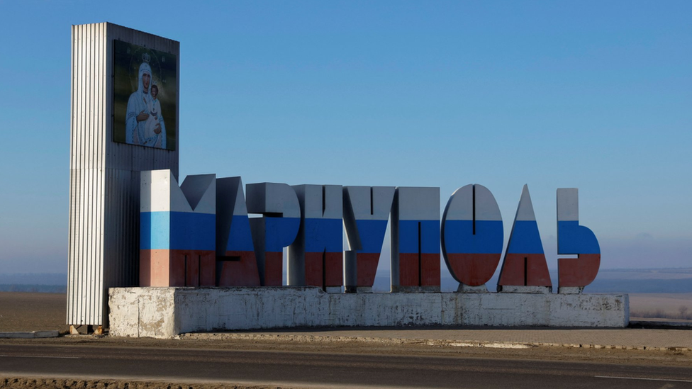 A sign for Mariupol in the colours of the Russian flag