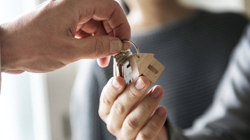 Persona recibe las llaves de una casa
