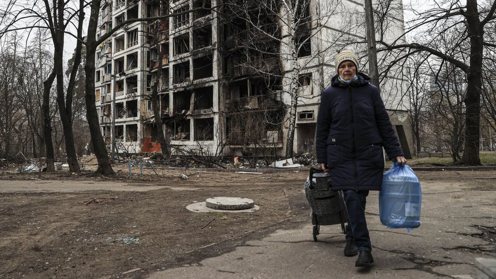 Una mujer camina frente a un edificio completamente destruido después de un bombardeo ruso en el distrito Svyatoshinsky de Kiev, Ucrania, el 30 de marzo de 2022.