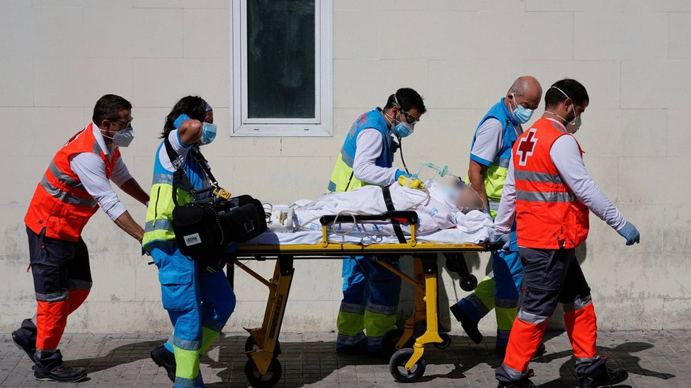 Trabajadores de la salud trasladan paciente en el hospital 12 de octubre.