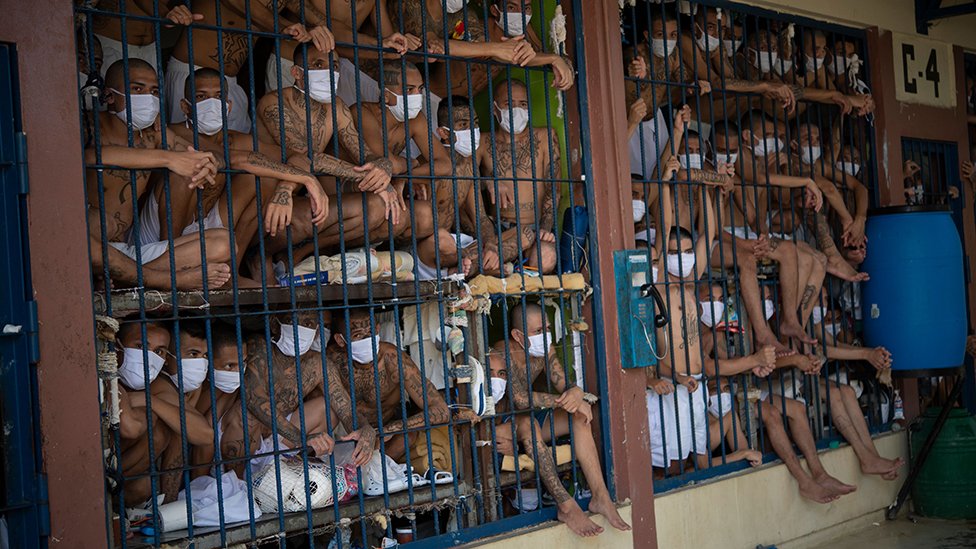Prisoners crammed close together behind bars in a prison in El Salvador during a review in 2020
