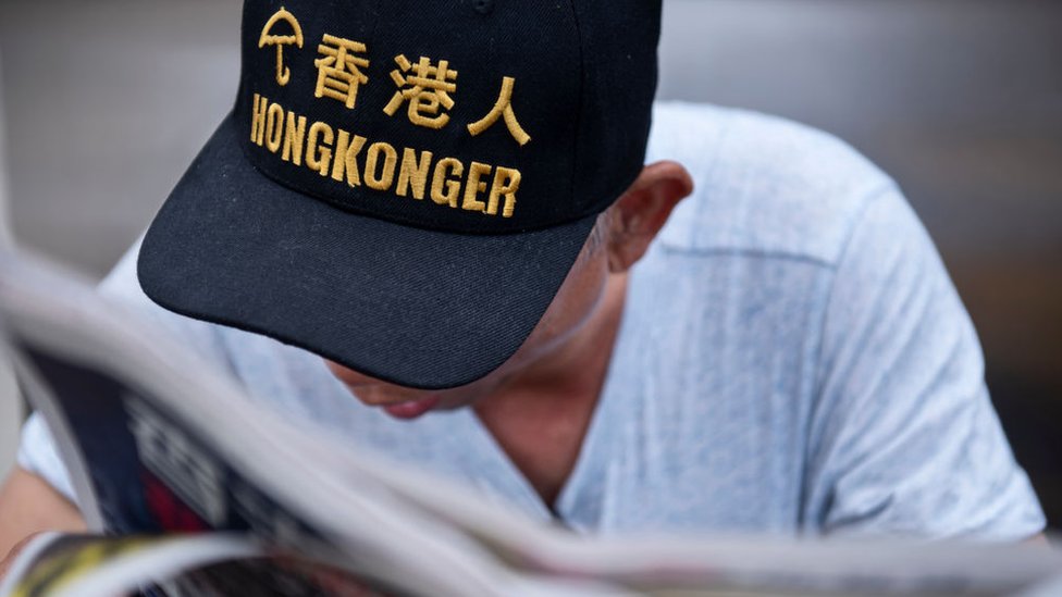 Протестующий и сторонник движения «Зонтик» читает газету в комплексе Legco в Гонконге 21 июня