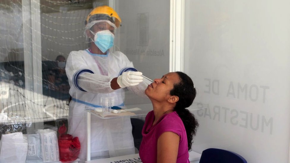 A health worker takes a COVID-19 test sample on a woman on November 3, 2020 in Medellin, Colombia.