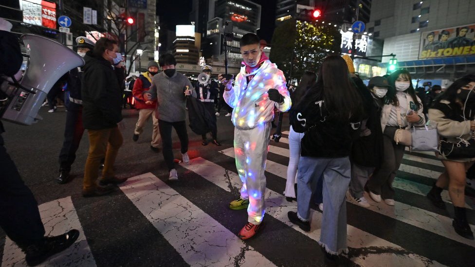 Un hombre con ropa de luces recibe el 2022 en las calles de Tokio, Japón
