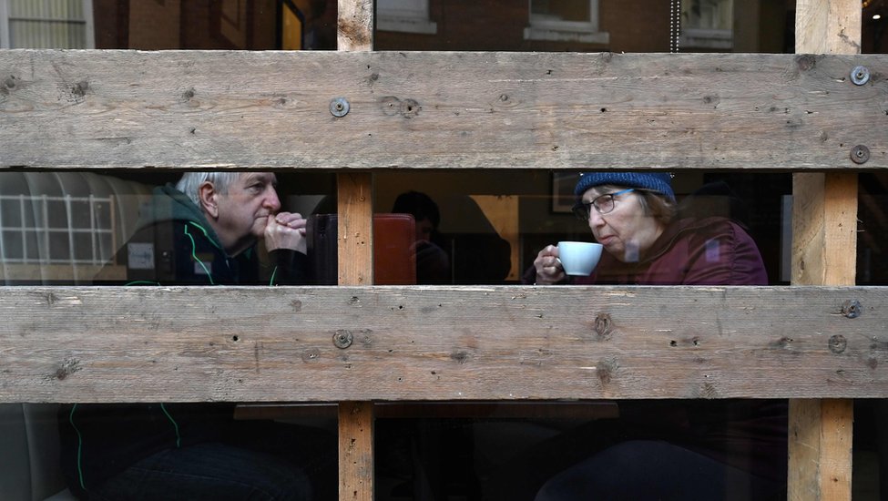 Пара сидит в заколоченном кафе перед ежегодным футбольным матчем «Королевская Масленица»