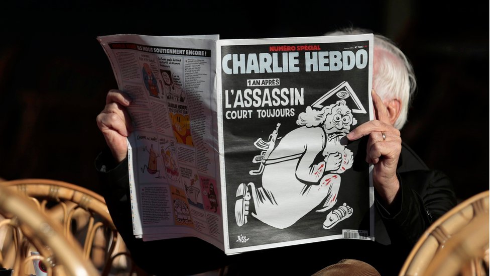 Мужчина читает специальный юбилейный выпуск французской сатирической газеты Charlie Hebdo в кафе в Ницце, 6 января 2016 года.
