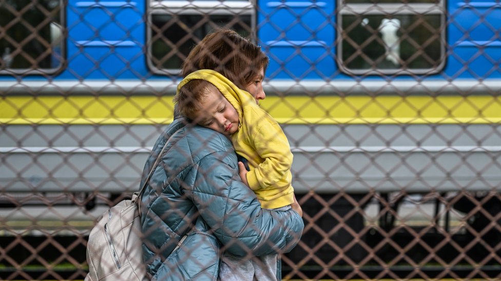 PRZEMYSL, POLAND - SEPTEMBER 30: A Ukrainian woman carries her child as they get off a train from Zaporizhzhia at Przemysl train station on September 30, 2022 in Przemysl, Poland. Russia declared the annexation of 15 percent of Ukrainian territory, sending more Ukrainians to flee across the border into Poland whilst other Ukrainian refugees who struggled to settle in Europe since the Russian invasion in February are crossing back into Ukraine. (Photo by Omar Marques/Getty Images)