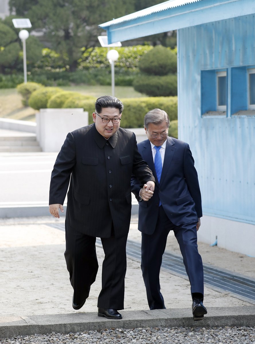 South Korean President Moon Jae-In (R) and North Korean leader Kim Jong-Un (L) cross the military demarcation line (MDL) from North Korea"s area at the Joint Security Area (JSA) on the Demilitarized Zone (DMZ) in the border village of Panmunjom in Paju, South Korea, 27 April 2018. South Korean President Moon Jae-in and North Korean leader Kim Jong-un are meeting at the Peace House in Panmunjom for an inter-Korean summit. The event marks the first time a North Korean leader has crossed the border into South Korea sine the end of hostilities during the Korean War. EPA/KOREA SUMMIT PRESS POOL