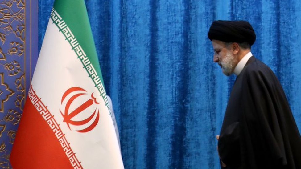 Presidente iraniano Hossein Amir-Abdollahian perto de uma bandeira iraniana