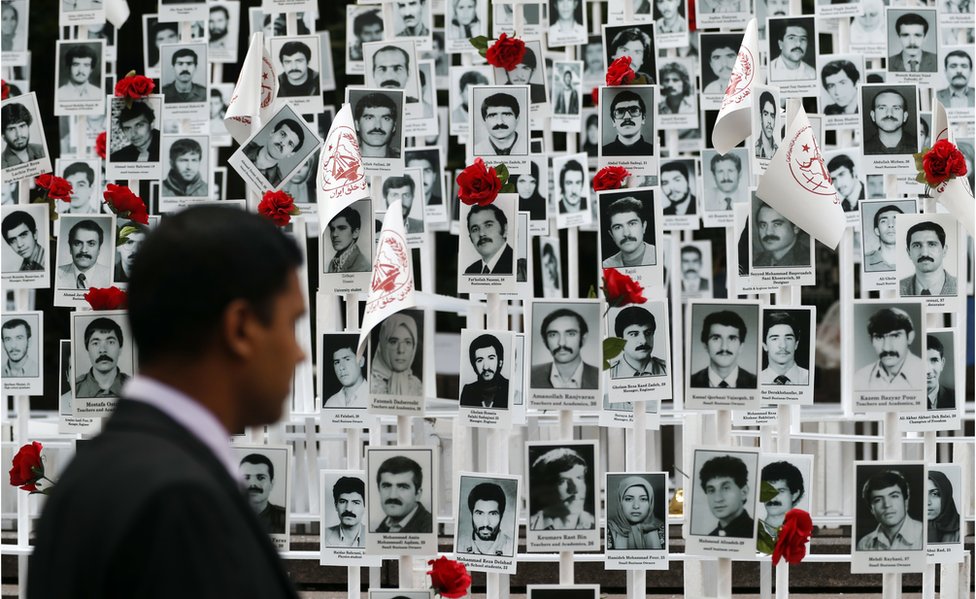 Мужчина смотрит на фотографии людей, казненных в Иране во время митинга у штаб-квартиры ООН в Нью-Йорке во вторник, 20 сентября 2016 года.