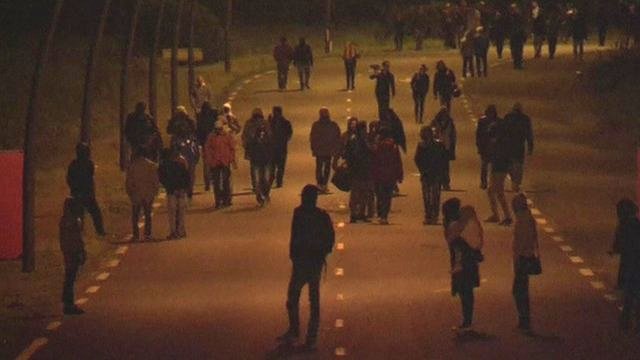 Migrants walk towards Channel tunnel at night