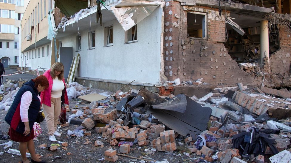 Dos mujeres miran los escombros de un edificio administrativo en Járkiv