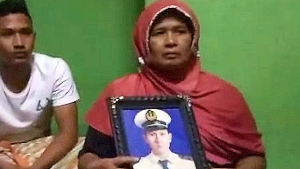 Afrida holding photo of her son at her home in Padang Sumatra