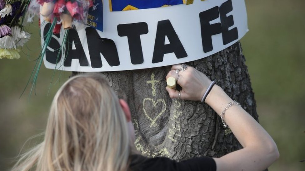 طلاب المدرسة من يتذكرون ضحايا الحادث بكتابة اسماءهم على الأشجار