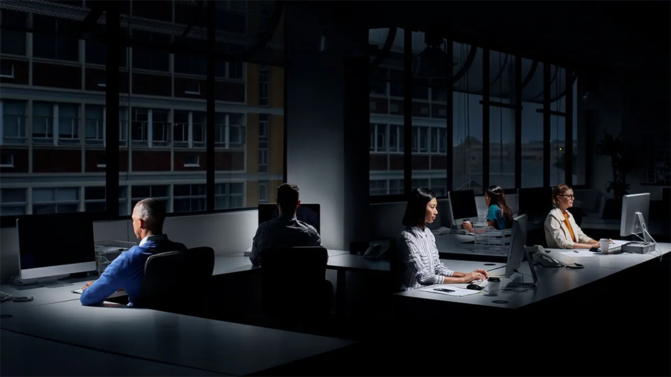Personas trabajando en una oficina oscura