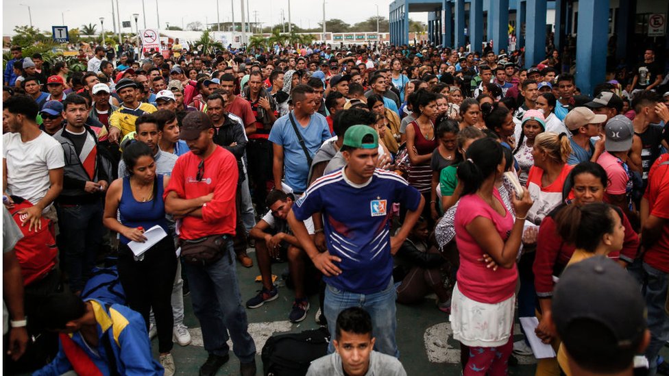 Venezolanos esperando para realizar los trámites migratorios en la aduana de Perú.