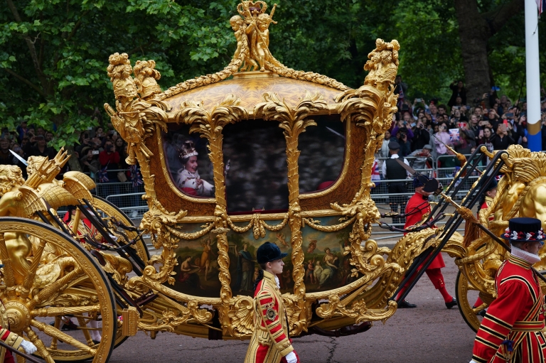 Queen's hologram in Gold State Coach,