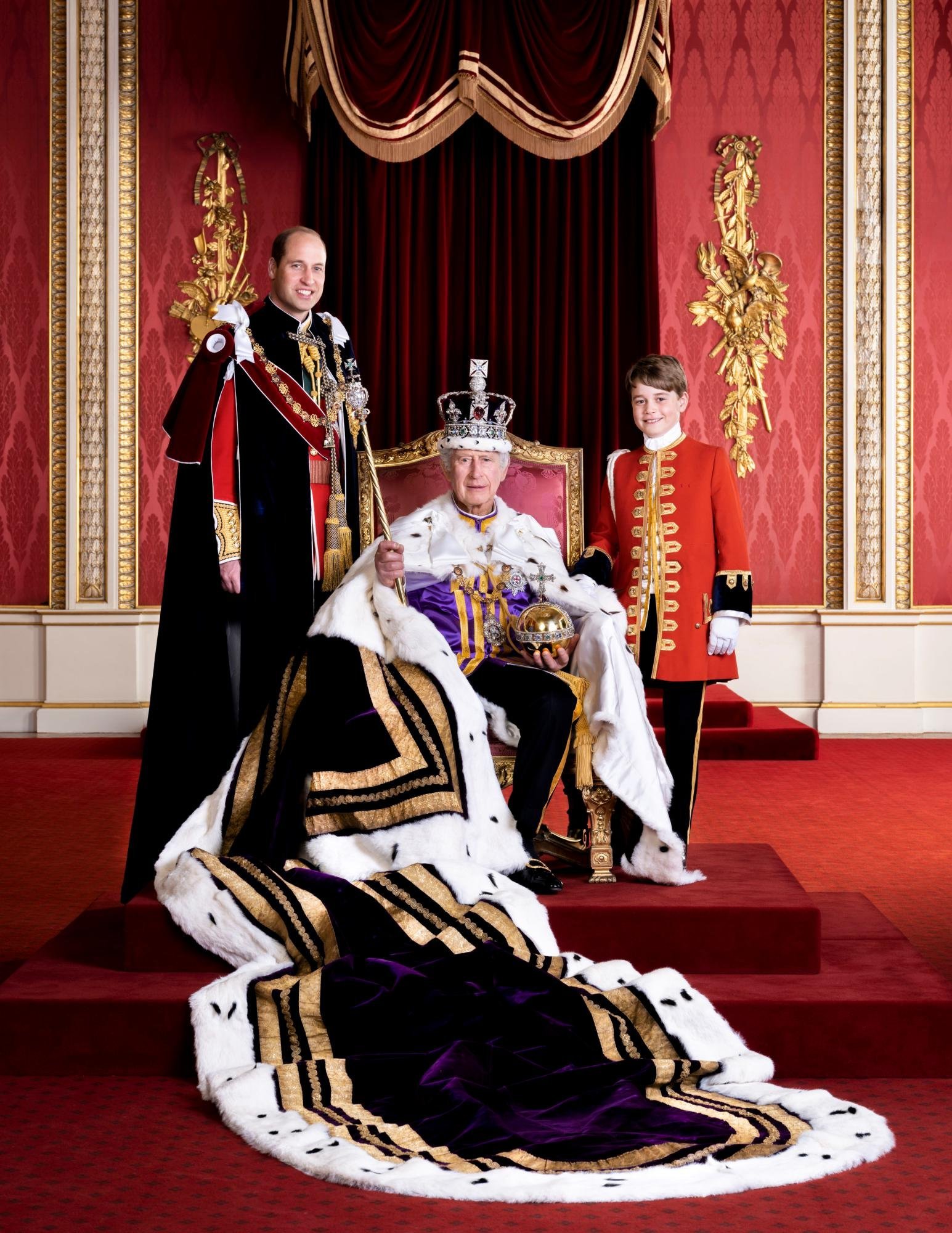 King Charles III is pictured at Buckingham Palace seated on the throne with his son Prince William by his side and Prince George on the other side.