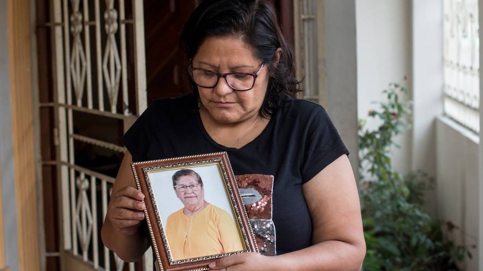 Elsa Maldonado holding a portrait of her mother