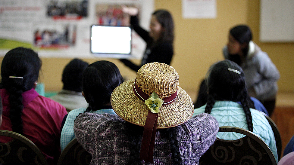 Женщины смотрят демонстрацию того, как работает сайт Quipu