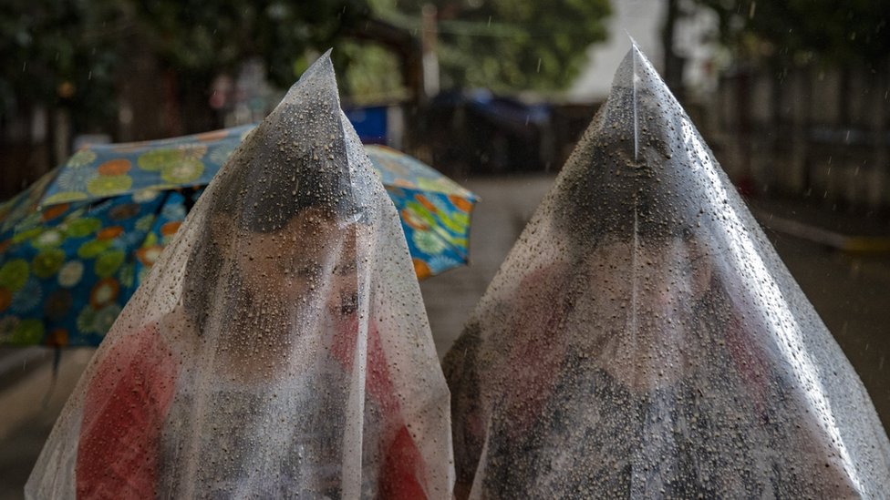 Жители носят полиэтиленовые пакеты для защиты от пепла
