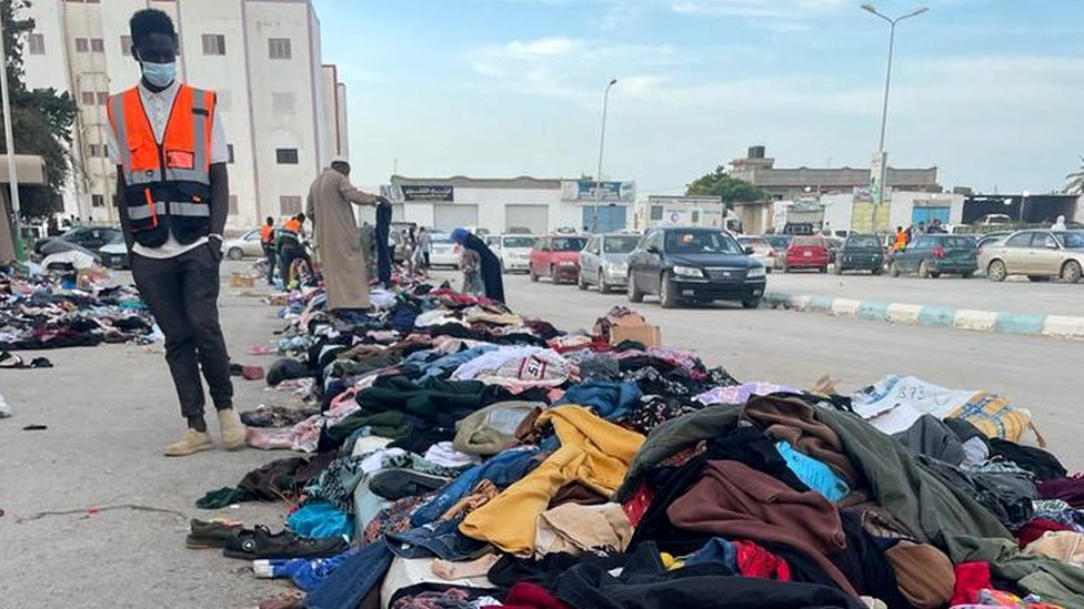 Orang-orang mengambil baju-baju sumbangan di Derna.