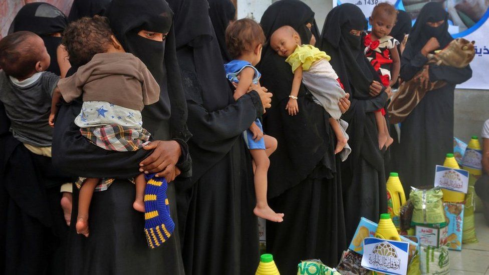 Mujeres haciendo fila para recibir alimentos