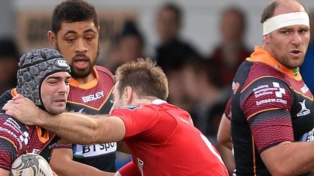 Adam Hughes of Newport Gwent Dragons is tackled by Tomas O’Leary