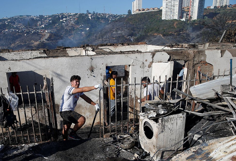 Personas trabajando tras el paso del incendio en Viña del Mar.