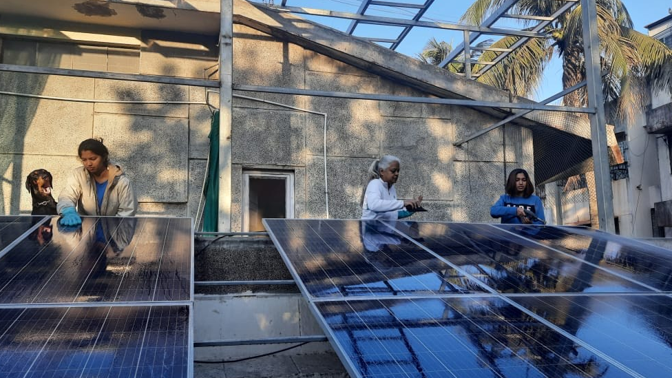 The two sisters, Taneesh and Neeshita, with their mother cleaning solar panels