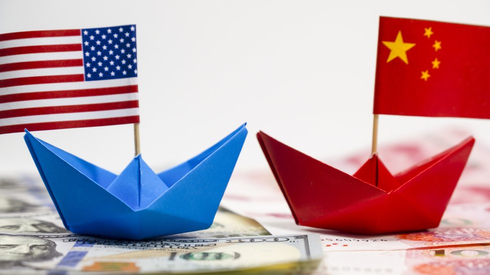 Maqueta con dos barcos de papel y las banderas de Estados Unidos y China.