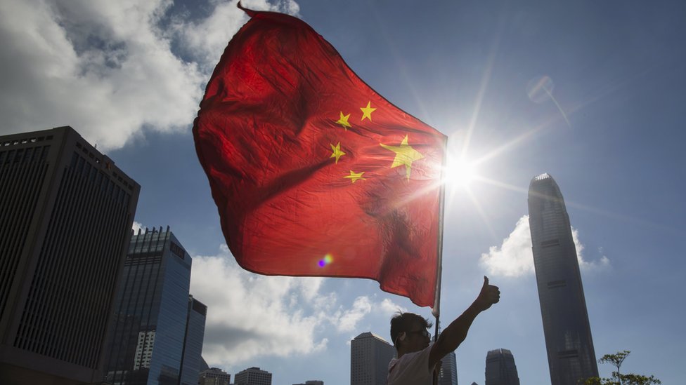 Una bandera de China frente a edificios en Hong Kong