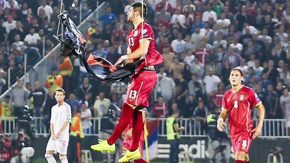 Serbia player Stefan Mitrovic grabs the banner at the stadium in Belgrade, 14 October