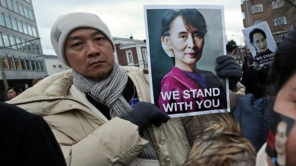 A supporter holds a picture of Myanmar"s leader Aung San Suu Kyi during a demonstration outside the International Court of Justice