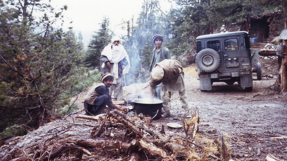 Мужчины готовят пищу на костре