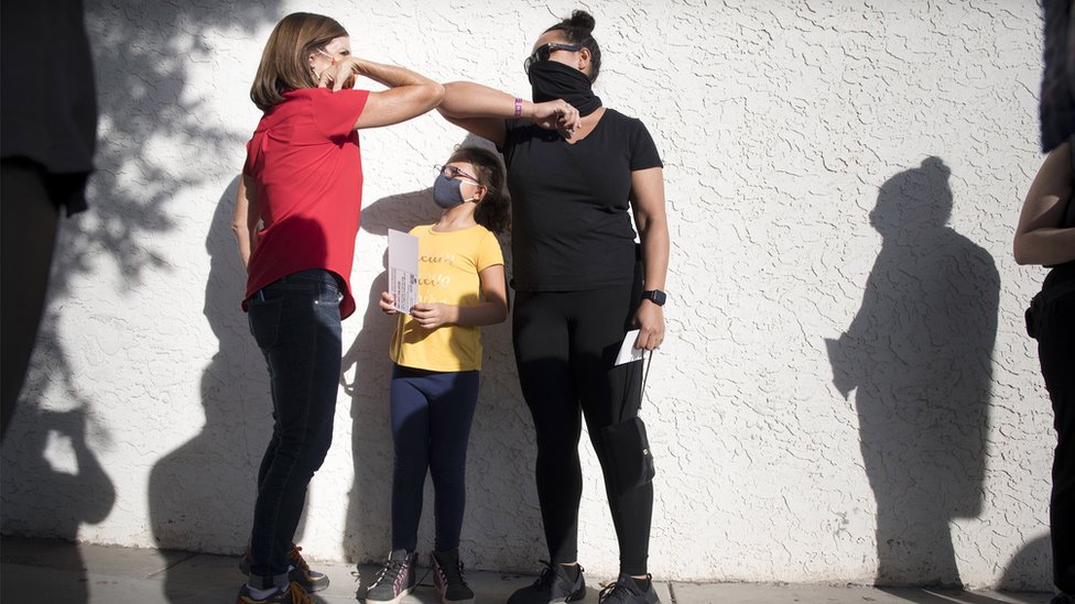 Voters on Election Day pass a socially distant elbow bump